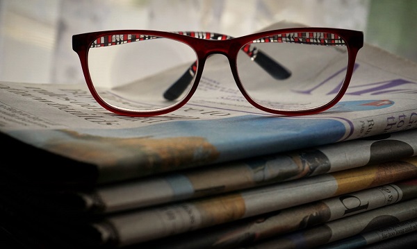Brille auf Zeitungsstapel